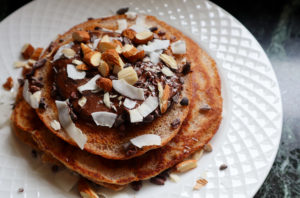 Almond flour pancakes with toppings on a white plate